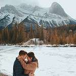 couple kissing in front of mountain